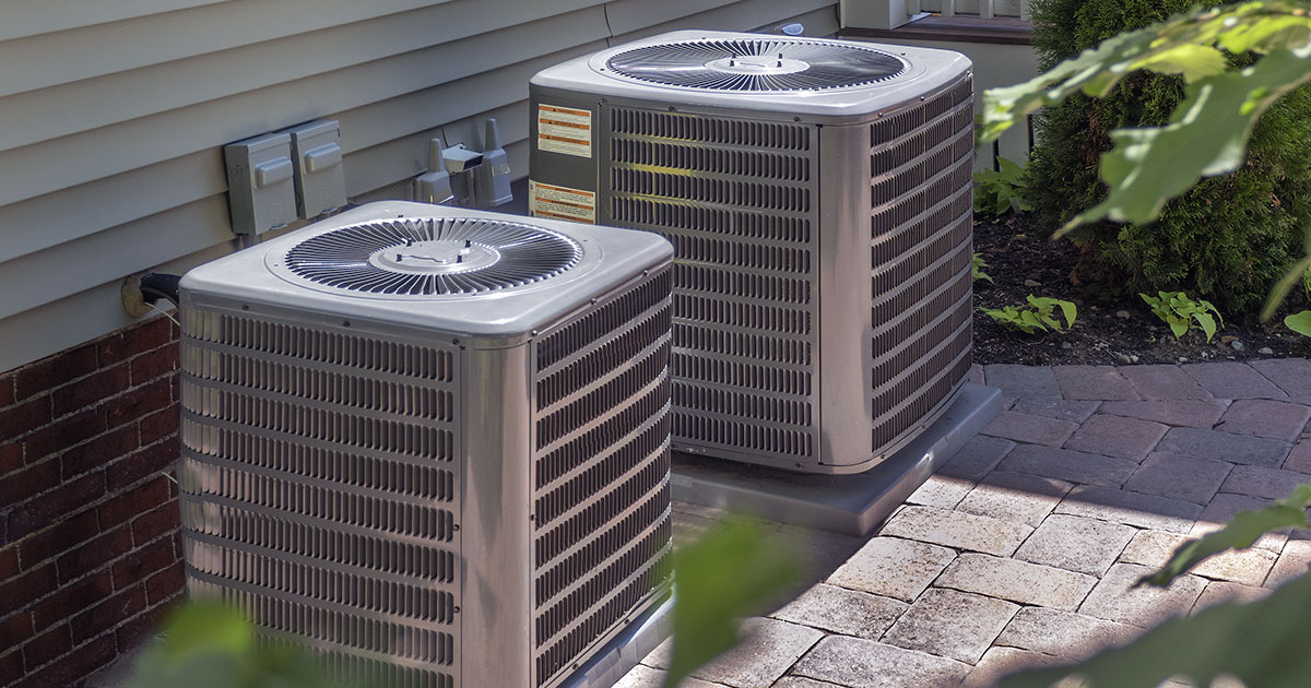 Outdoor HVAC units side by side outside a home